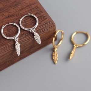 Detailed close-up of S925 sterling silver feather pendant hoop earrings in gold and silver