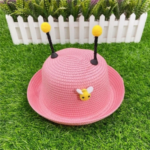 Pink kids straw sun hat featuring cute bee patch and yellow pom-poms for summer