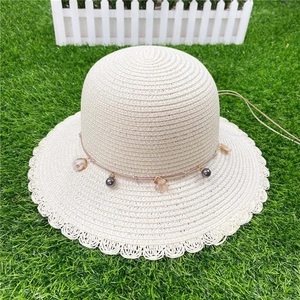 Beige wide brim straw sun hat with lace wavy edges and black beaded decorative cord