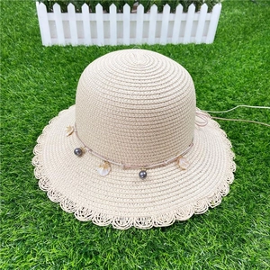 Gray bead straw sun hat for women with wavy brim and shell charms for beach vacations