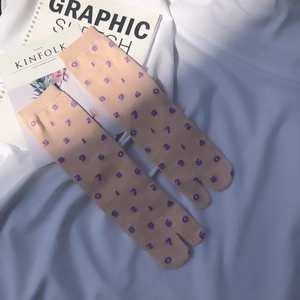 Flat lay of pink Japanese tabi socks with purple numbers on a white cloth surface