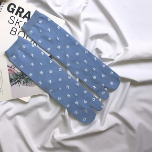 Close-up of blue tabi socks with white numbers on soft white fabric background