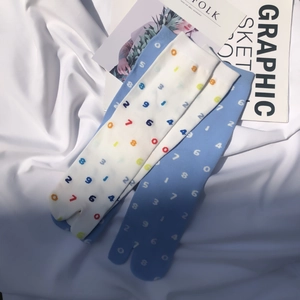 Detail of white and light blue Tabi socks featuring colorful scattered number patterns