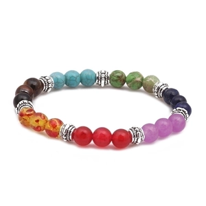 7 Chakra stone bead bracelet with silver flower spacers on a white background