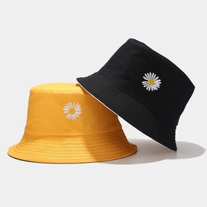 Double-sided daisy embroidered bucket hats in bright yellow and classic black cotton fabric