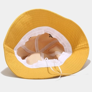 Detail of yellow cotton bucket hat interior showing white sweatband and adjustable drawstring