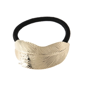 Detailed close-up of a golden metal leaf ornament on a black elastic hair tie for women