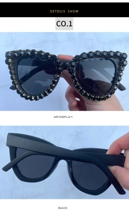 Detailed view of cat-eye sunglasses featuring hand-set black crystals on black frames