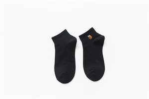 Close-up of black cotton ankle socks featuring a cute owl embroidery on the ribbed cuff