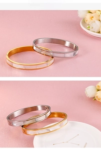 Detail of gold and silver stainless steel bangles featuring elegant mother of pearl inlays