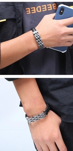 Close-up of black braided leather and silver stainless steel chain bracelet on wrist
