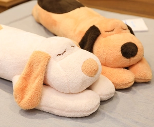 Detail showing two plush dog pillows in white and brown resting on a cozy bed
