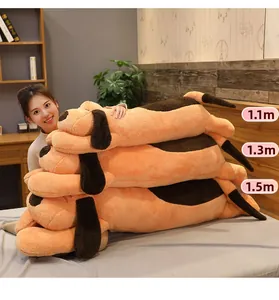 Three sizes of orange plush puppy dogs ranging from 1.1m to 1.5m on a grey bed