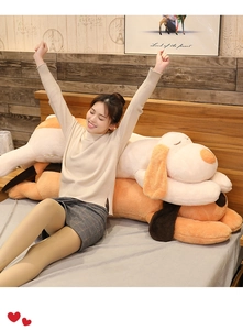 Detailed view of large plush dog pillows in white and orange with long floppy ears