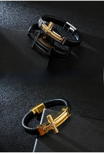 Detail of men's punk cross bracelet with woven leather and textured metal magnetic clasp