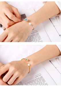 Détail du bracelet ajustable œil bleu avec perles et breloques émaillées au poignet