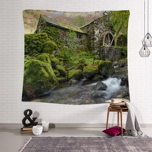 Detail of bohemian wall tapestry featuring scenic European cottage and rustic waterwheel
