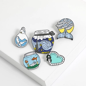 Detailed view of creative enamel pins featuring whales, starry night art, and fish tanks