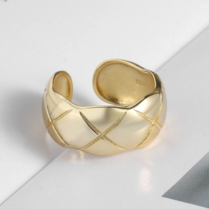 Detailed macro view of S925 sterling silver stamp on golden lattice pattern open ring