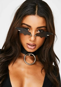 Detail of bat-wing sunglasses and black choker with polished silver metal ring