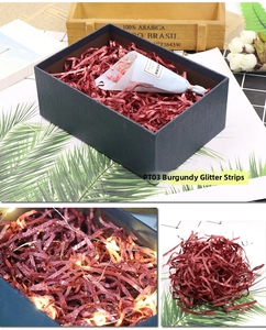 Close-up of wine red glitter shredded paper raffia filler for decorative gift boxes