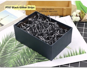 Sparkling black glitter raffia paper shreds inside a blue gift box for holiday packaging