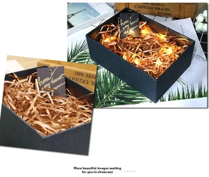 Close-up of luxury dark blue gift box with metallic raffia filler and warm LED lights