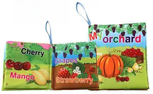 Détail d'un livre en tissu pour bébé avec motifs de fruits et légumes et cordon bleu