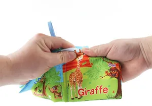 Détail montrant les mains tirant sur un livre en tissu pour bébé résistant aux déchirures