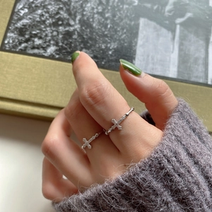 Close-up of model wearing 925 silver cross rings with cubic zirconia stacked together