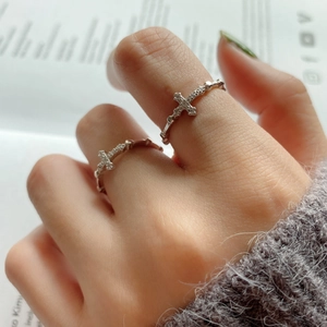Detailed view of 925 silver cross rings with cubic zirconia stones on a model hand