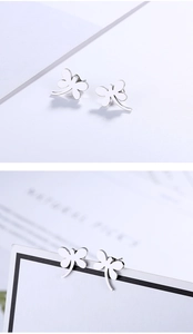 Detailed view of silver dragonfly stud earrings with polished stainless steel finish