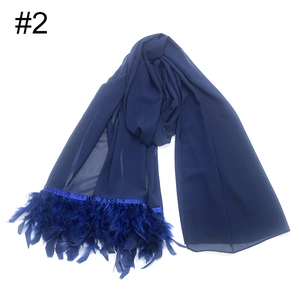 Detalle de bufanda de gasa azul marino con elegantes adornos de flecos de plumas