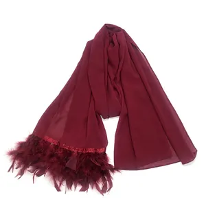 Detalle de bufanda de gasa color burdeos con elegantes flecos de plumas a juego