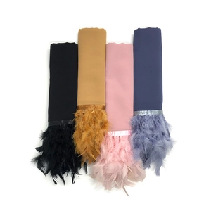 Muestra plana de cuatro bufandas de colores lisos con flecos decorativos de plumas finas