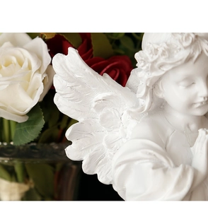 Macro detail of feathered wings and delicate face of a white resin angel sculpture
