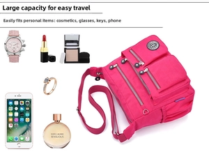 Detail showing the large storage capacity of a bright pink nylon crossbody bag