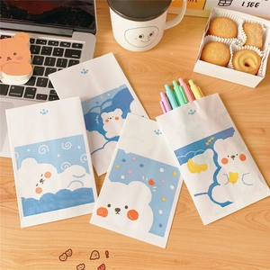 Cute cartoon bear paper bags on a wooden desk with a laptop and creative props
