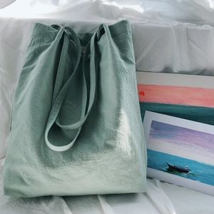 Detail of mint green washed linen tote bag with natural wrinkled texture and dual handles