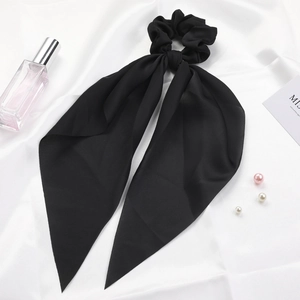 Elegant black satin hair scrunchie with long ribbons on white silk background