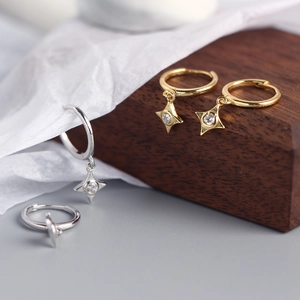Detail of S925 silver and gold star drop earrings with sparkling cubic zirconia crystals