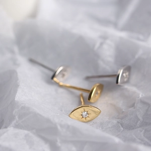 Macro shot of minimalist S925 sterling silver eye-shaped stud earrings with zircons