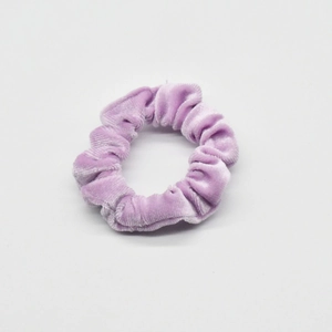 Detail of soft lavender velvet fabric texture and stitching on elastic hair scrunchie