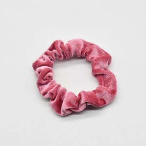 Close-up of pink velvet scrunchie showing detailed soft fabric texture and elastic pleats