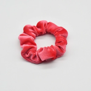 Detail of red velvet scrunchie showing soft fabric texture and elastic hair band design