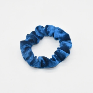 Close-up of high-elasticity blue velvet scrunchie showing soft textured fabric folds