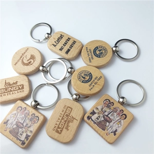 Detail showing custom engraved beech wood keychains with natural grain and metal rings