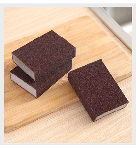 Close-up of three brown carborundum sponges on a wooden board for kitchen cleaning
