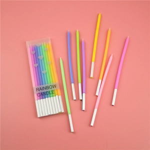 Rainbow gradient tall candles for birthday cakes shown in transparent packaging on pink background