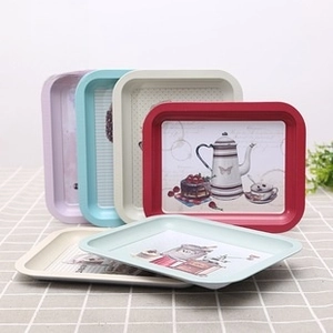 Detail of vintage tinplate snack trays with retro tea illustrations in pastel colors